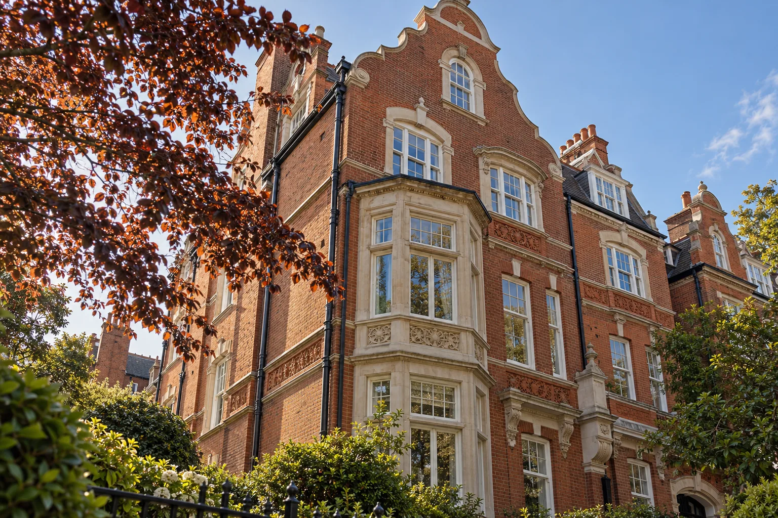 Concept image: red-brick Dutch-gabled house with pale window surrounds beside a copper beech